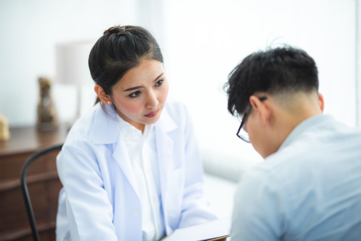 Female doctor in a white coat listening attentively during a patient consultation