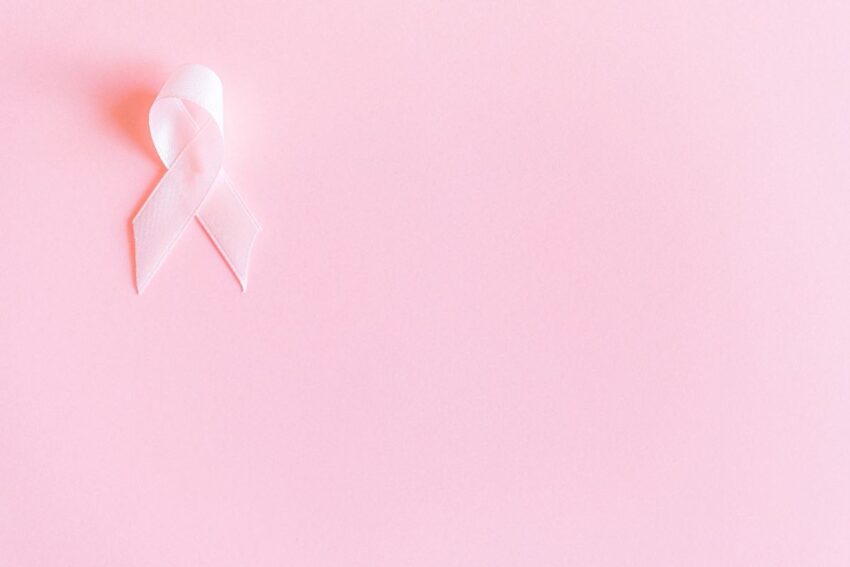 Pale pink awareness ribbon on a soft pastel pink background