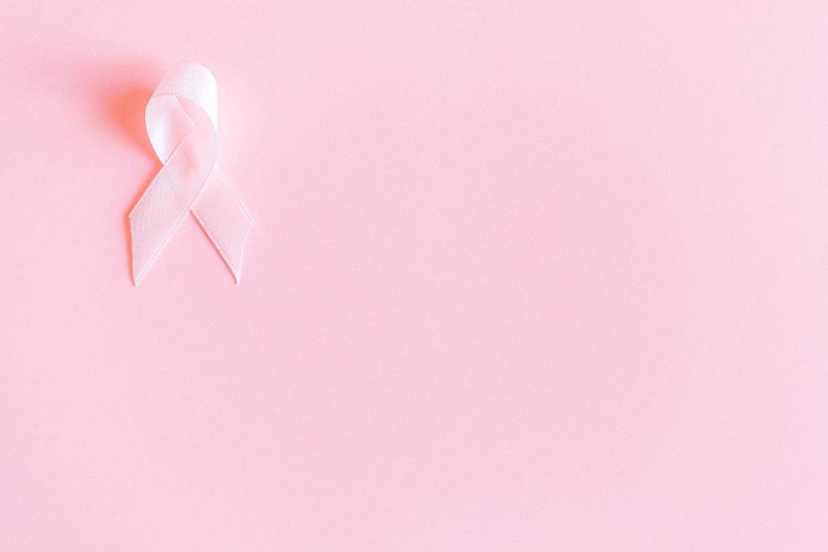 Pale pink awareness ribbon on a soft pastel pink background
